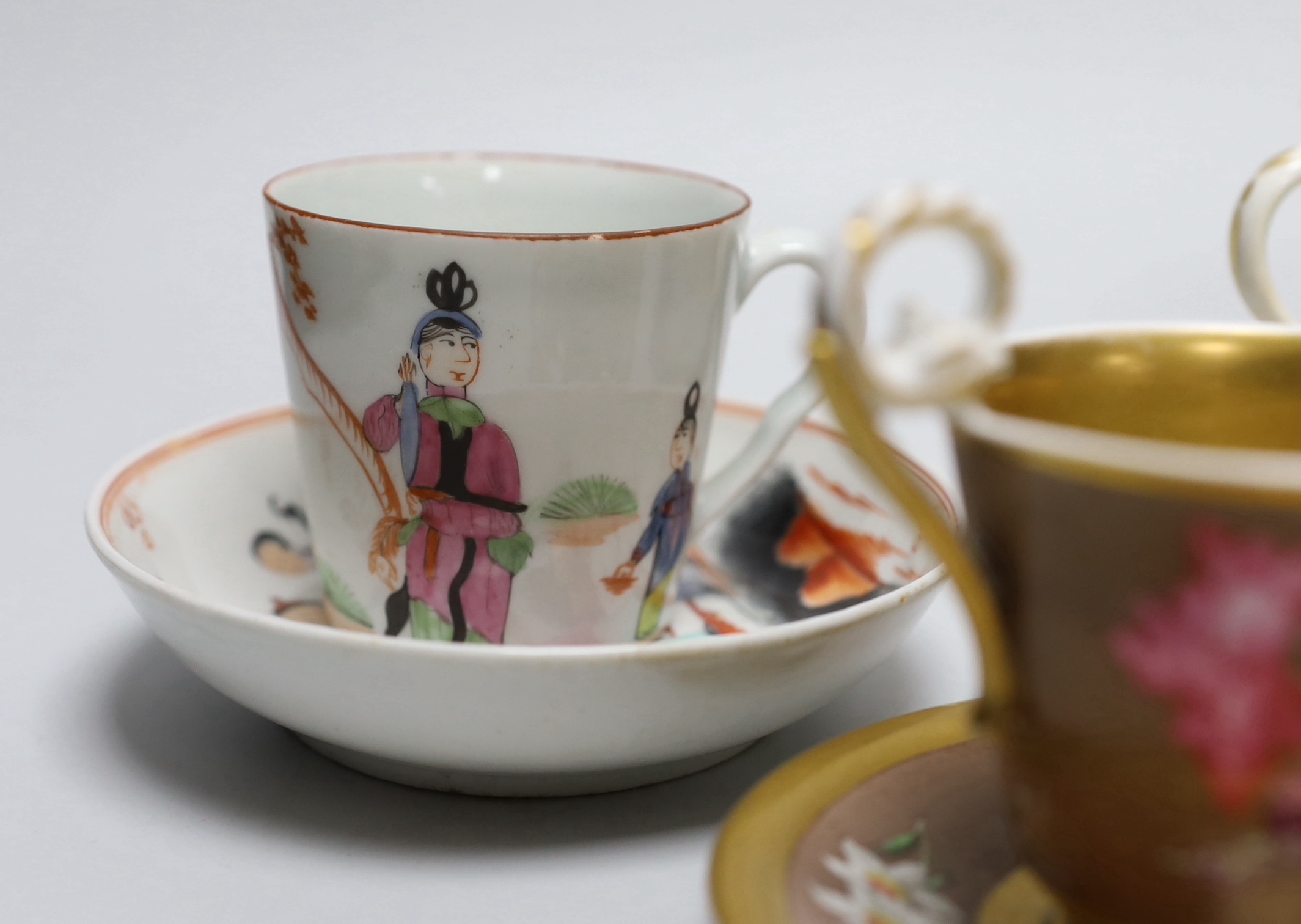 A group of early 19th century English porcelain cups and various saucers to include a Spode two handled chocolate cup and saucer (10)